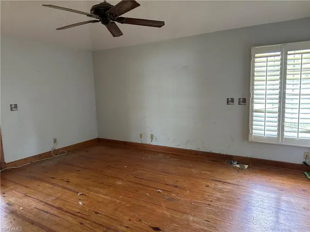 Unfurnished room with a healthy amount of sunlight, hardwood / wood-style flooring, and ceiling fan