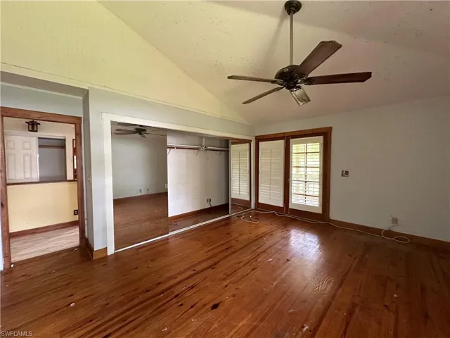 Unfurnished bedroom with vaulted ceiling, ceiling fan, and hardwood / wood-style floors