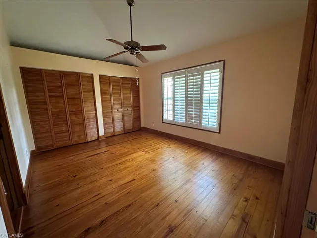 2ND bedroom featuring multiple closets, ceiling fan, and hardwood / wood-style floors
