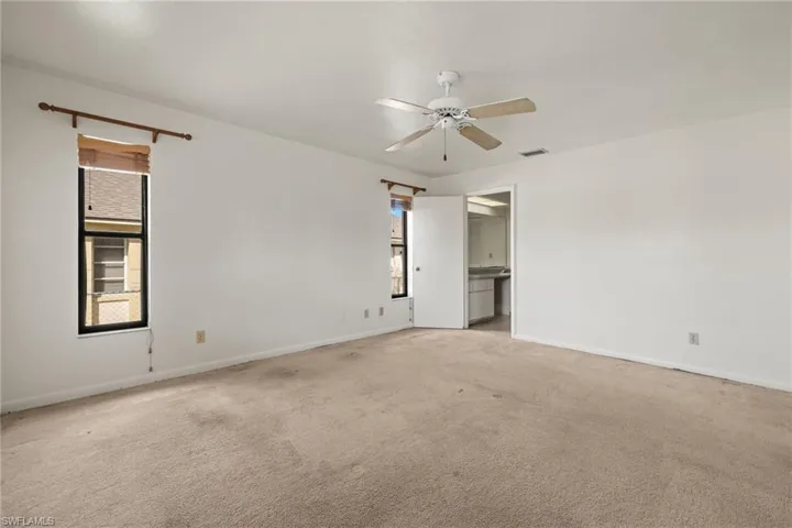 Carpeted spare room featuring ceiling fan