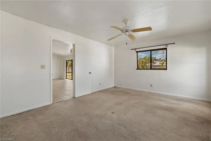 Carpeted spare room with ceiling fan
