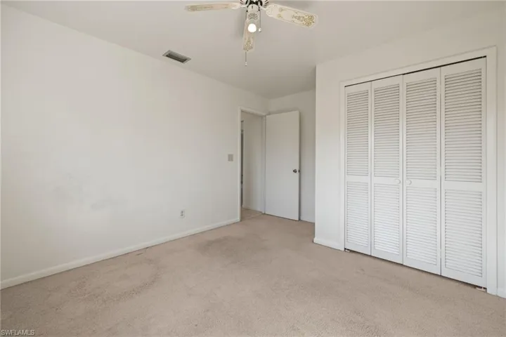 Unfurnished bedroom with light colored carpet, a closet, and ceiling fan