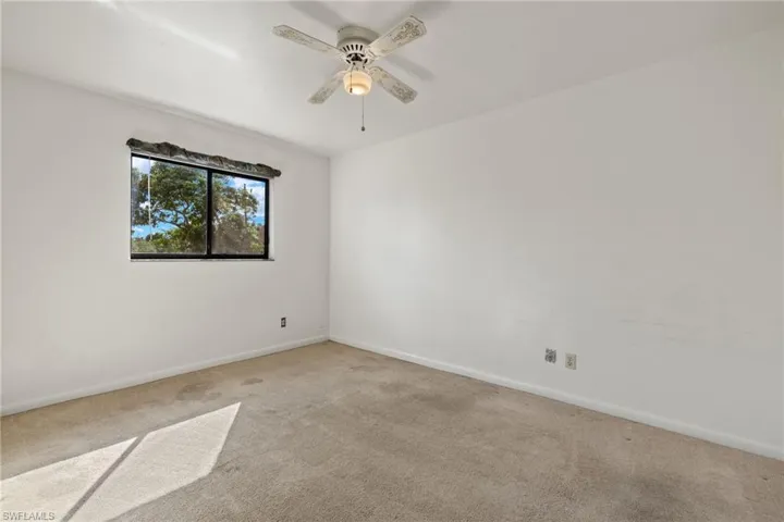 Carpeted spare room featuring ceiling fan