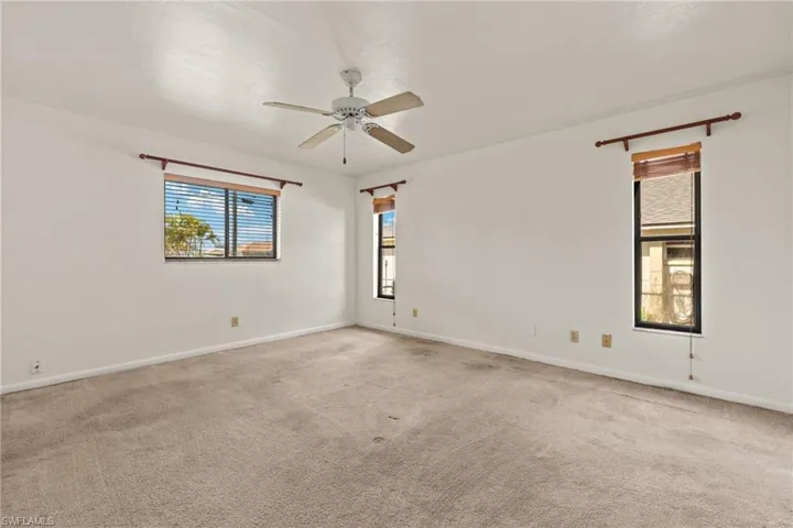Carpeted spare room with ceiling fan