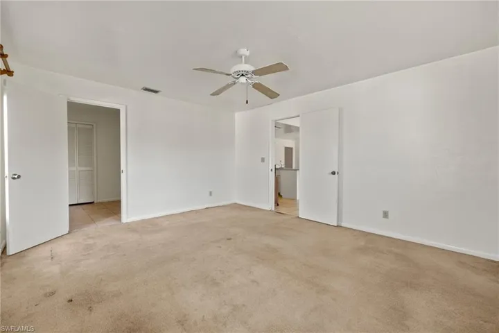 Carpeted spare room featuring ceiling fan