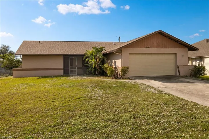 Ranch-style home with a garage and a front lawn