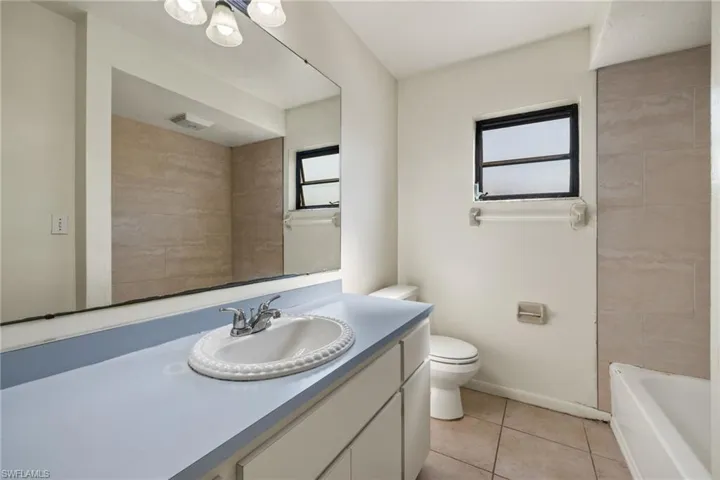 Bathroom featuring vanity, toilet, and tile patterned flooring