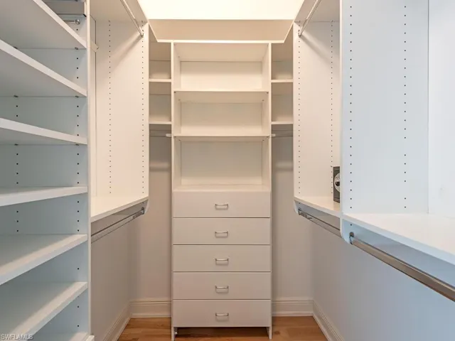 Walk in closet with light wood-style flooring