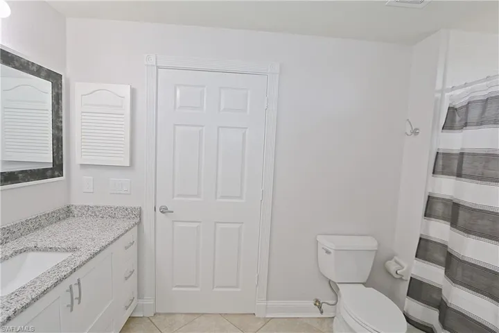 Full bath with vanity, tile patterned floors, and a shower with curtain