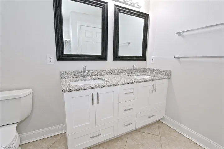 Full bath featuring double vanity and tile patterned floors