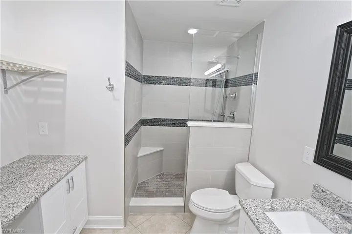 Bathroom featuring vanity, walk in shower, and tile patterned floors
