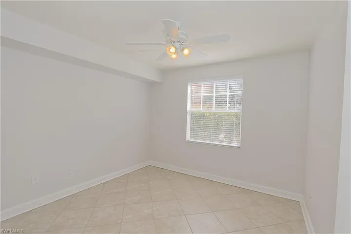Spare room with a ceiling fan and light tile patterned floors
