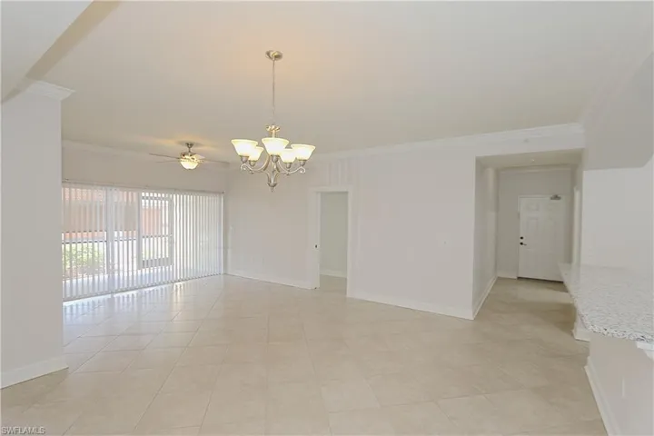 Unfurnished room featuring crown molding, a chandelier, a ceiling fan, and light tile patterned flooring