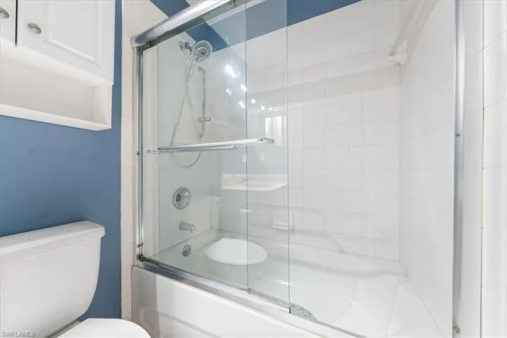 Full bath with toilet and enclosed tub / shower combo