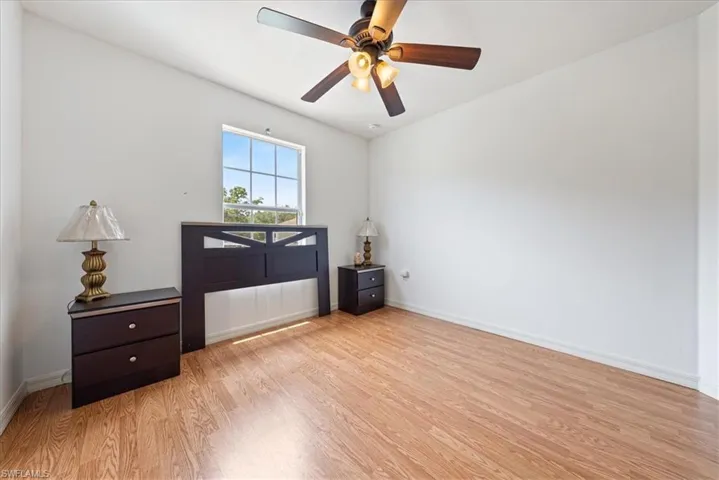 Empty room with baseboards, ceiling fan, and light wood-type flooring