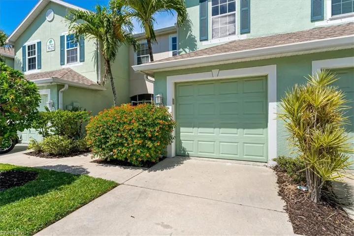 View of front of property with a garage, stucco siding, and driveway