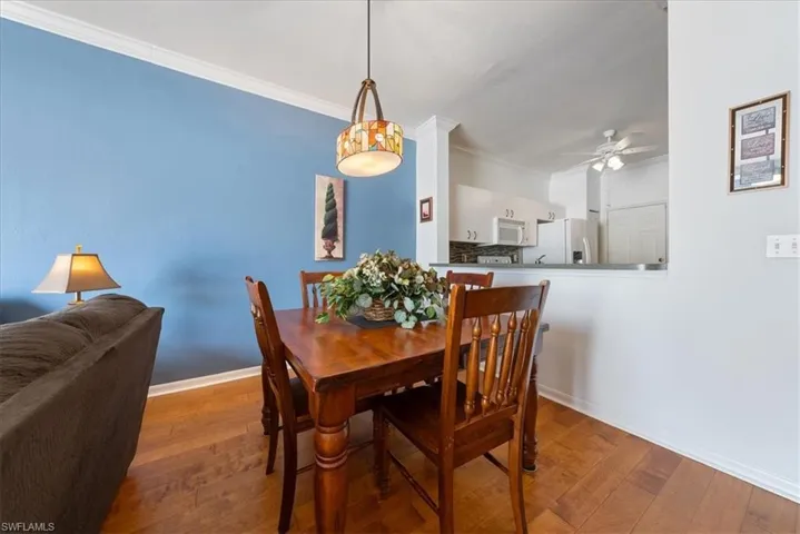 Dining area with baseboards, ornamental molding, ceiling fan, and wood finished floors