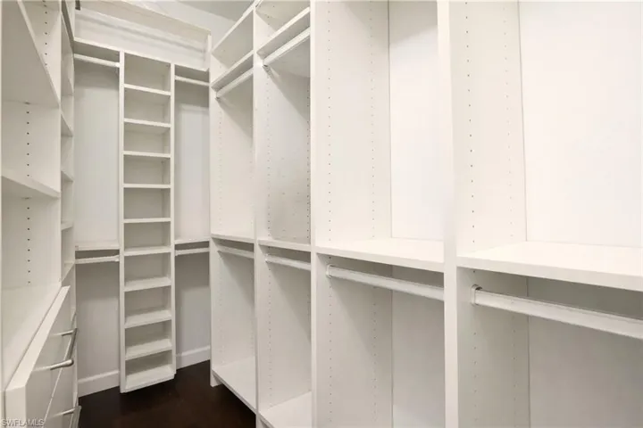Walk in closet featuring dark wood-style floors