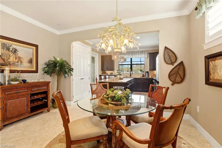 Dining area with ornamental molding, light tile flooring, and suspended lighting