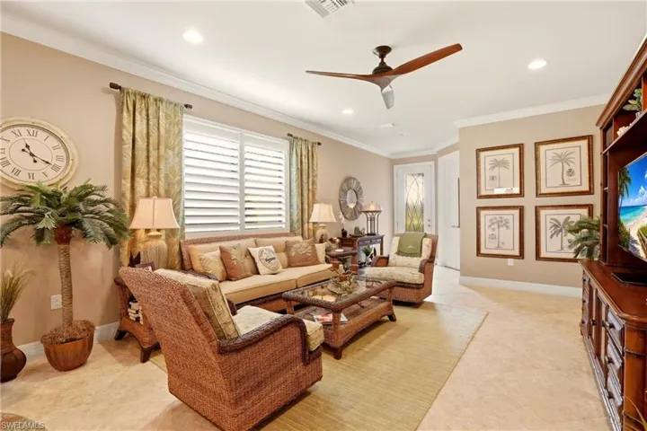 Living room View from the Dining area featuring ceiling fan, crown molding, recessed lighting, plantation shutters and light tile floors