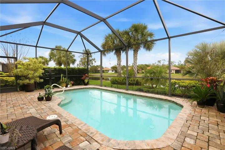 Outdoor pool with a sunroom, screened enclosure, and a patio area