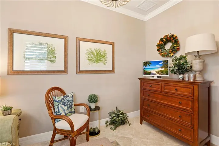 Den- featuring ornamental molding and light tile flooring laid on the diagonal.