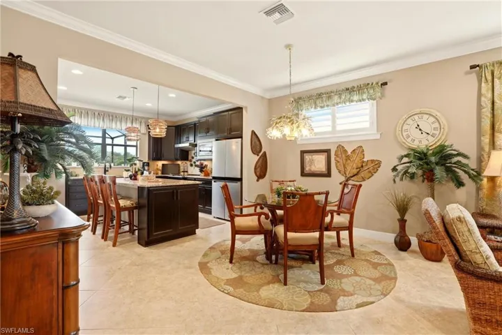 Dining area featuring ornamental molding, plenty of natural light, and suspended lighting