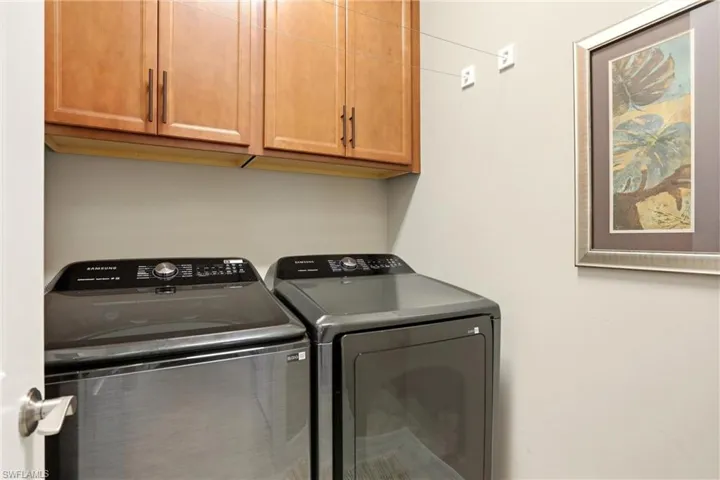 Laundry area with independent washer and dryer and cabinet space