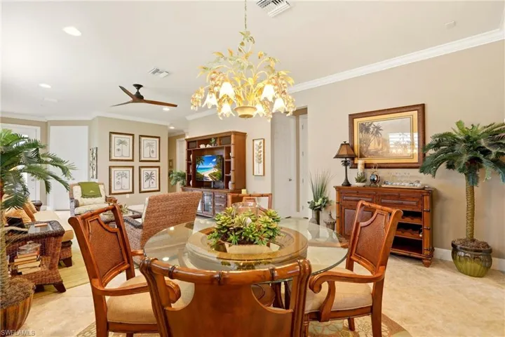 Dining room featuring ornamental molding, suspended lighting, light tile patterned flooring, and ceiling fan