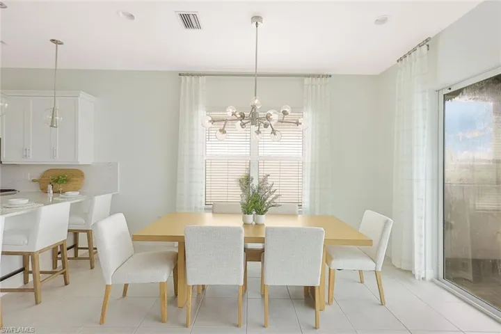 Tiled dining area featuring a wealth of natural light and a chandelier