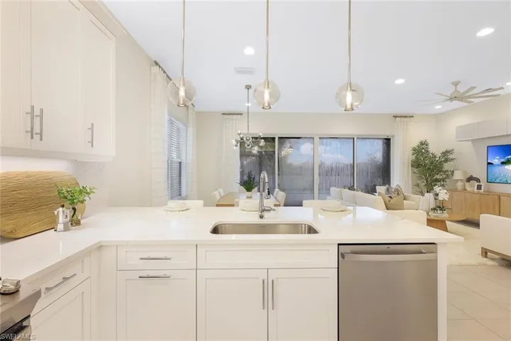 Kitchen featuring white cabinetry, ceiling fan, decorative light fixtures, sink, and dishwasher