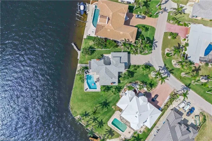 Welcome to your dream home! This Cape Coral gem stuns from the first glance – gorgeous facade, lush palms, and unbeatable riverfront vibes.