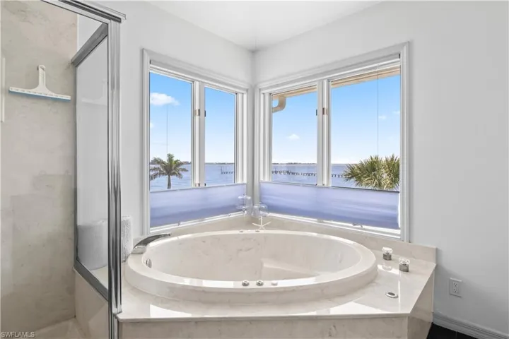 Spa-like ensuite with soaking tub, dual vanities, and walk-in shower.