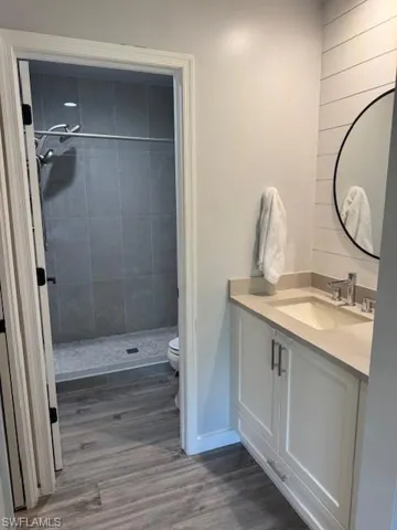 Bathroom with vanity, a stall shower, and dark wood-type flooring