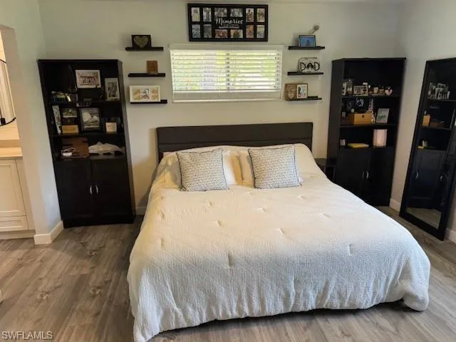 Bedroom featuring dark wood-type flooring and baseboards