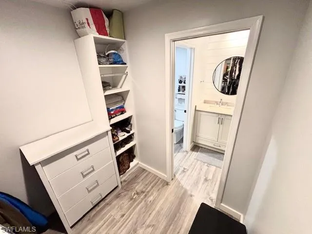 Spacious closet with light wood-style flooring and a sink
