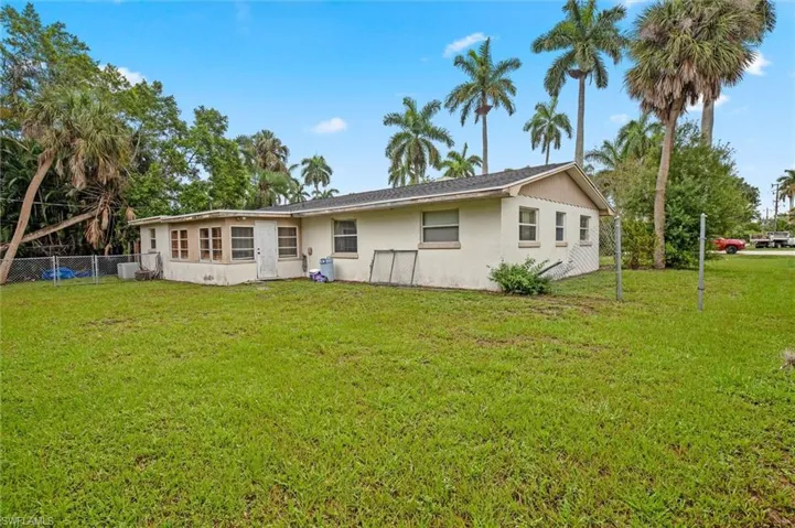 Rear view of house featuring a lawn