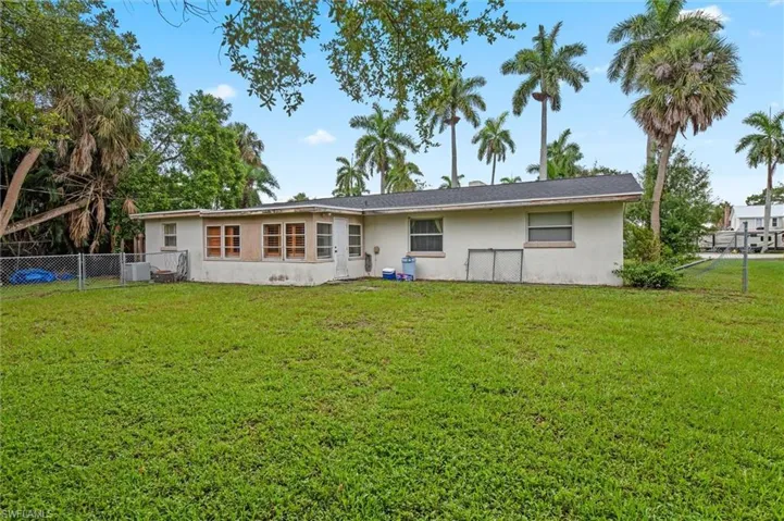 Back of property with a yard and central AC unit