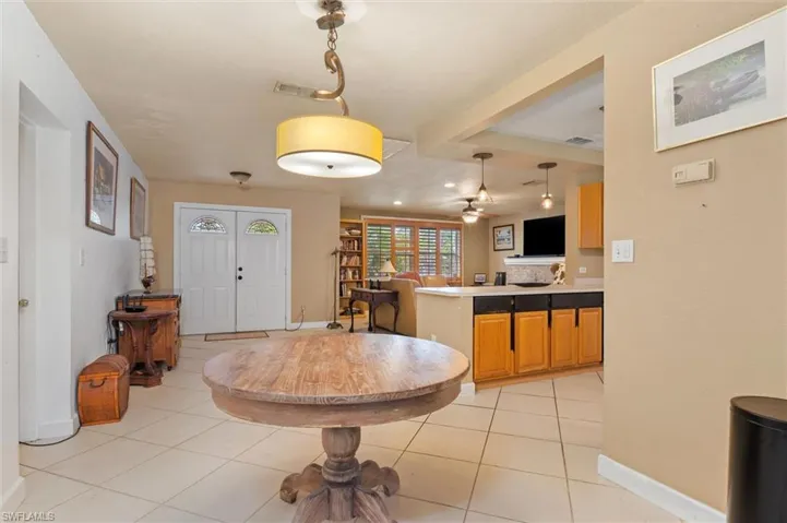 Kitchen featuring decorative light fixtures, ceiling fan, light tile floors, and kitchen peninsula