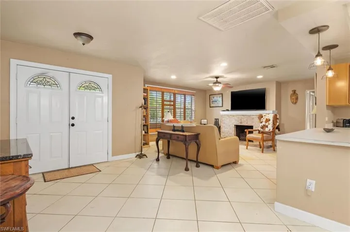 Foyer entrance with ceiling fan and light tile floors