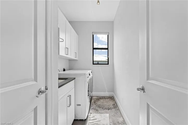 Laundry area featuring cabinets and washer and dryer