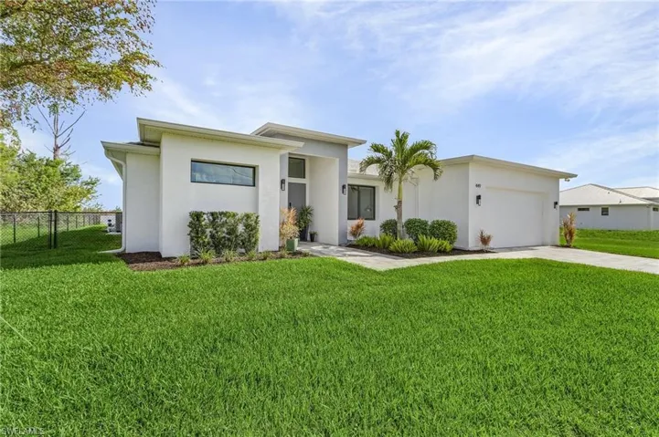 View of front of property with a front lawn and a garage
