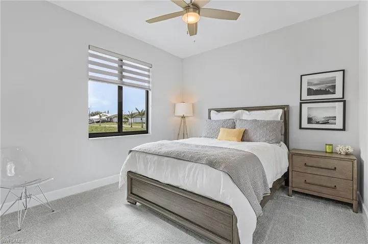 Carpeted bedroom featuring ceiling fan