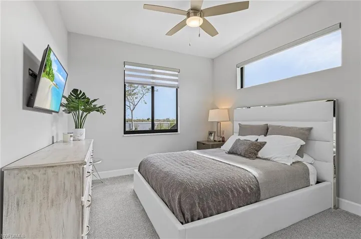 Bedroom with ceiling fan and light carpet