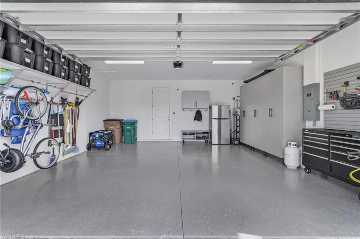 Garage with fridge and custom cabinets and storage racks