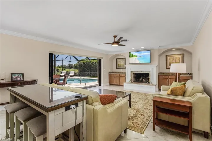 Living room featuring crown molding, ceiling fan, and light tile patterned floors