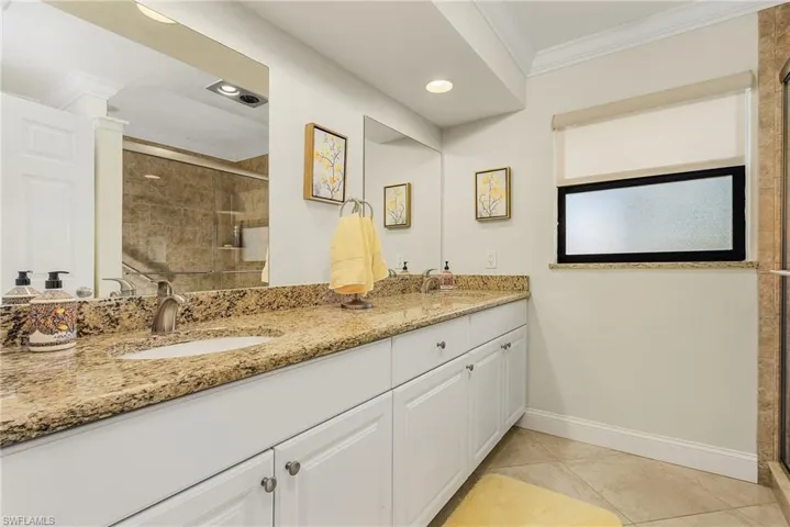 Guest Bathroom featuring vanity, ornate columns, a shower with door, and tile patterned floors