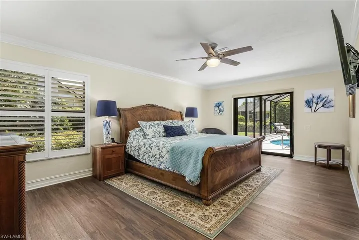 Master Bedroom featuring access to exterior, multiple windows, ceiling fan, and dark hardwood / wood-style flooring