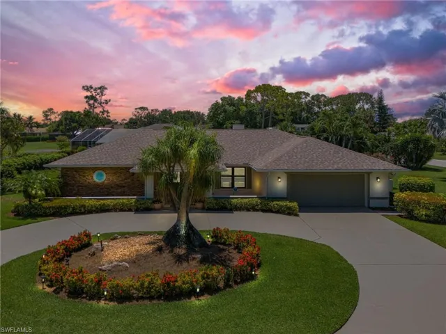 View of front of property featuring a garage and a lawn