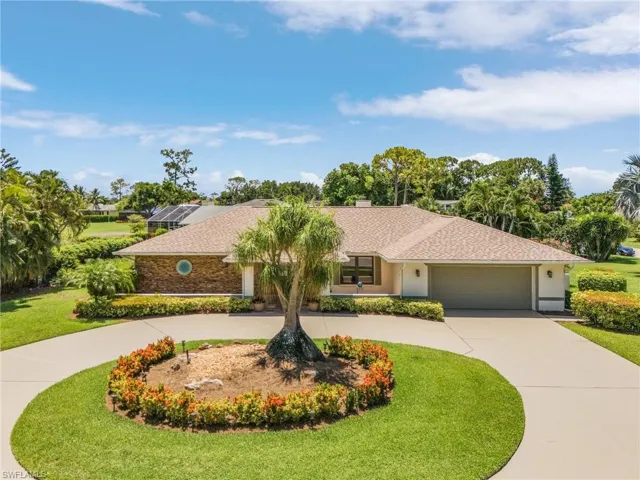 Ranch-style home with a front yard and a garage